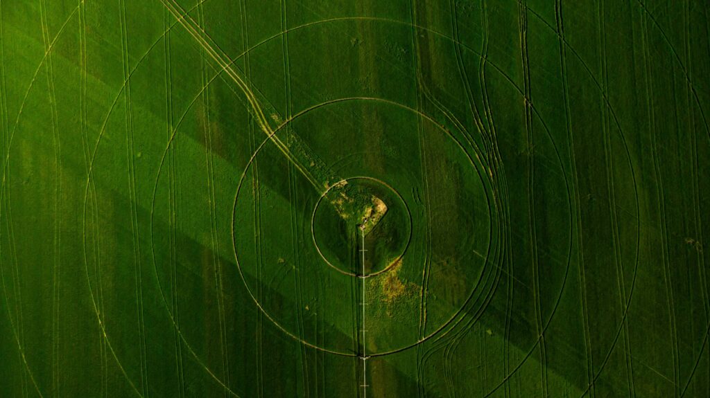 Green field aerial view with circular crop irrigation