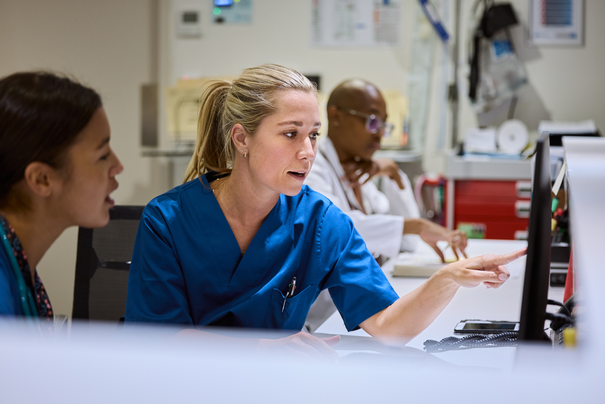 Nurses using computer at desk in hospital