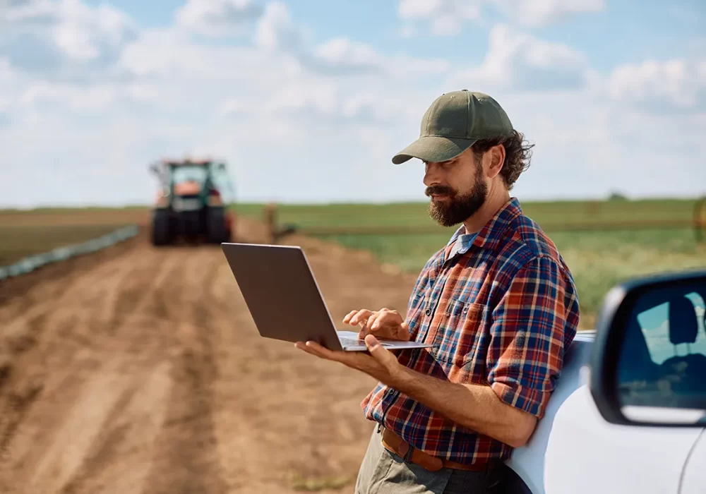 Farmer using laptop in field