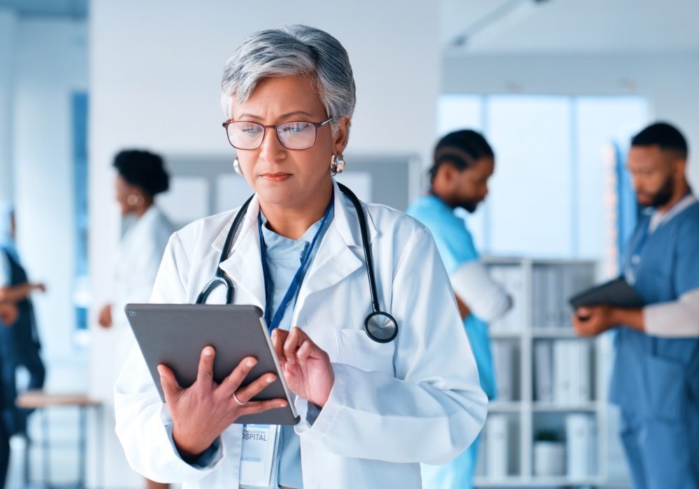 Mature woman, thinking or doctor on tablet at hospital for healthcare questions, research or schedule solution. Digital, app or surgeon brainstorming at clinic for Telehealth problem solving or faq