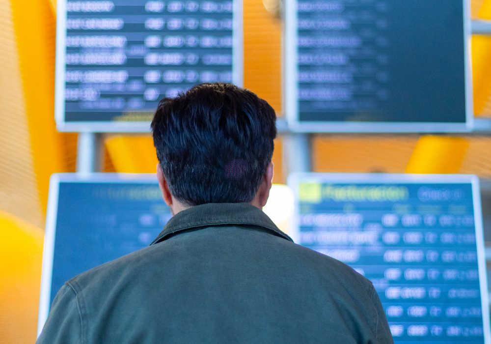 Traveler looking at airport timetable flight information